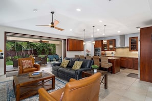 The living room of this Holua Kai at Keauhou rental with direct outside access, leather furniture, and a coffee table.