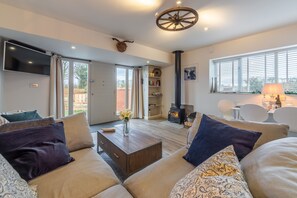 Wheelwrights, Sustead: Open-plan living area with wood burning stove