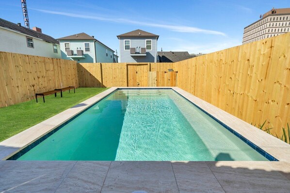 Fully-Fenced Pool with pool toys, towels, and lounge chairs