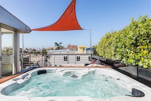 Private rooftop lounge with hot tub spa, fire pit, and BBQ grill.