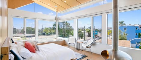 Sun-filled master bedroom with lofted ceilings, fire orb, and soaking tub.