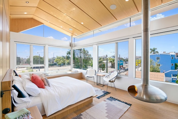 Sun-filled master bedroom with lofted ceilings, fire orb, and soaking tub.