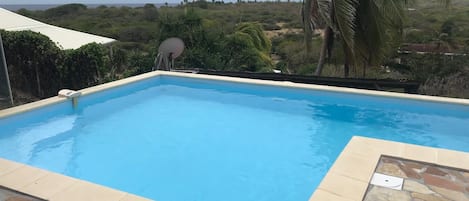 La nouvelle piscine de la villa Ocean View, en L avec sa banquette intégrée.
