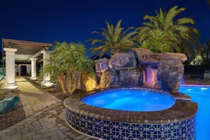 This enticing outdoor space combines the soothing warmth of a hot tub with the visual charm of a waterfall, providing a perfect setting for relaxation and enjoyment.