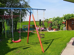 Swing, Playground, Outdoor Play Equipment, Public Space, Grass, Human Settlement, Tree, Recreation, Playground Slide, Leisure