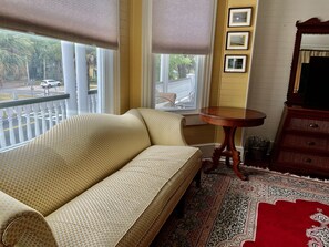 Camel back sofa & chair in sitting area in suite.