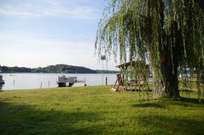 Additional lawn with fire pit, swingset, and dock.