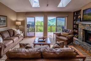 Great Room with leather furniture and stone fireplace and view