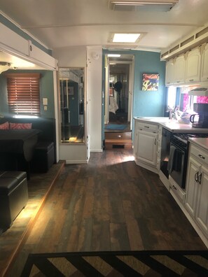 Kitchen area to the right with dishwasher. Stovetop but no oven. 