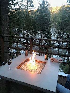The firetable  on the deck overlooking the river during sunset 