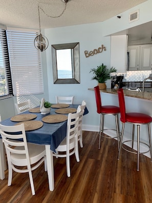 Spacious dining area offers 6 chairs at table and 3 bar stools at bar