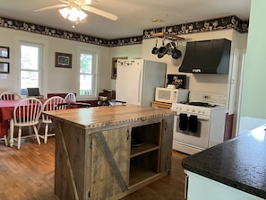 Kitchen with appliances, dishware, linens, and pots/pans.