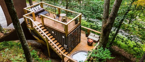 The Tiny Bunker features two decks with hot tub, fire table, dining& lounge area