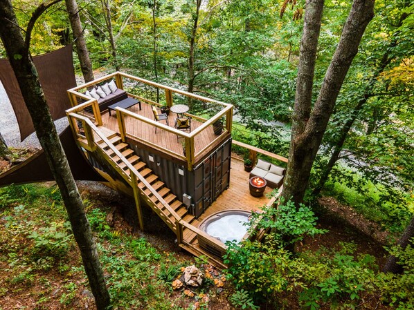 The Tiny Bunker features two decks with hot tub, fire table, dining& lounge area
