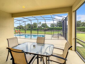 Outdoor dining area with serene poolside views and a cozy atmosphere.