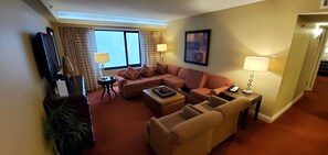 Living room with plenty of seating spaces and large TV.