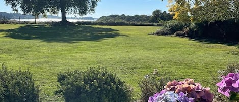 Vue de la terrasse sur le jardin et le golfe en arrière plan