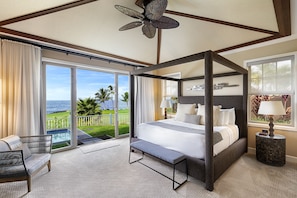 Primary bedroom of the Holua Kai Kona condo rental with ornate bed frame and armchair.