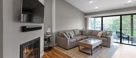 Large Sectional Sofa, coffee table, smart tv, sound bar, and gas fireplace.