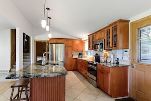 Large kitchen with double door refrigerator, electric stove, dishwasher and microwave.
Breakfast bar seating for four.