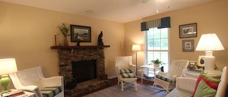 The den with turn of the century wicker furniture and a propane fireplace.