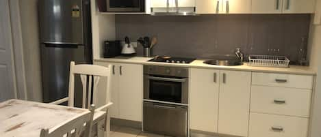 Kitchen with cutlery, dishes, cookware, coffee machine