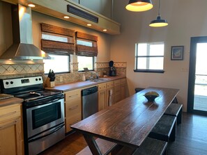 Well stocked open concept kitchen with stove, cooktop, dishwasher and views!