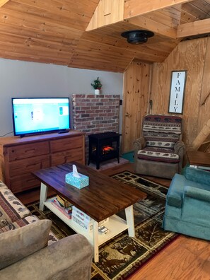 Cozy cabin has a sofa, recliner and cozy chair. 