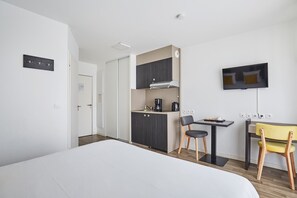 Discover this inviting space complete with a functional kitchenette, a designated dining area, and modern amenities for a pleasant stay.