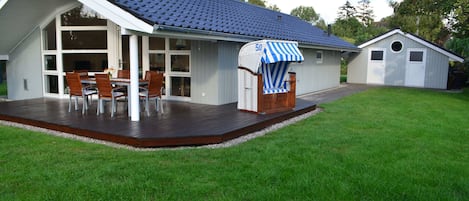 großzügige Holzterrasse mit Strandkorb