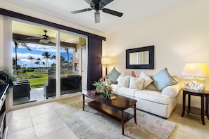 The living area of this Hali'i Kai condo with direct lanai access, couch, and coffee table.
