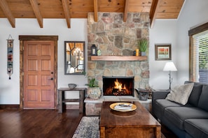 Main level living room features beautiful stone, wood burning fireplace.