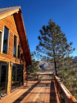 A wall of glass, including two French doors, opening on a wide deck