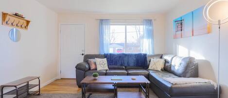 As you enter, you are greeted by a bright living area with comfy sectional to relax and unwind.
