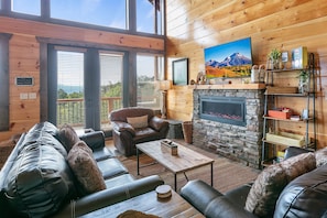 Open concept living room with TV and contemporary electric fireplace. Great view