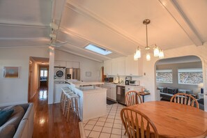 Open kitchen, with bar stool seating as well as dining table.