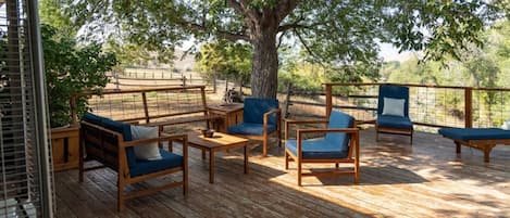 Large spacious wood deck with plenty of seating and shade tree.  Enjoy lounging out here and enjoying the views while conversing with friends or family.