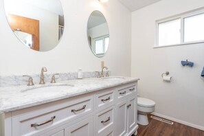 Beautifully updated full bathroom with double sinks and natural light.