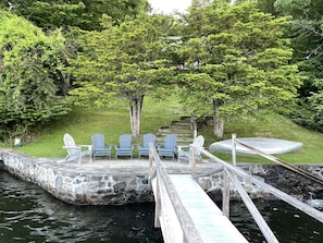 Large stone patio at waters edge with stone steps into the water. 