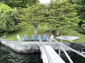 Large stone patio at waters edge with stone steps into the water.