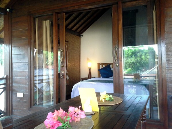 King sized bed with vaulted ceiling with exposed beams. 