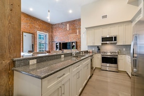 Cook and dine easily in the fully stocked kitchen, equipped with all stainless steel appliances, gas range, basic cookware, and a dining area for a comfortable meal at home. Entertain at the bar with seating for four.