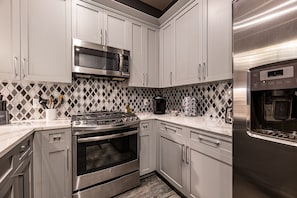 Cook and dine easily in the fully stocked kitchen, equipped with all stainless steel appliances, gas range, basic cookware, and a dining area for a comfortable meal at home. Entertain at the large bar, also with available seating for 4 guests and a table with 6 seats.