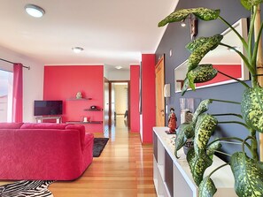 Red-themed entrance, bathed in natural light, welcomes you to a cozy, well-lit living space. #refuge #warm #livingroom