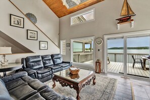 The living room's large windows let in natural light, creating a warm and inviting space.