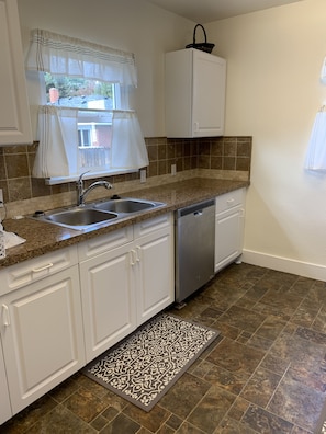 Fully equipped kitchen with disposal, dishwasher, dishes and pots and pans.  