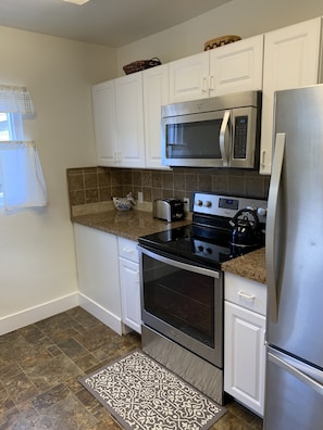 Kitchen with stove, dishwasher, microwave, large refrigerator.  