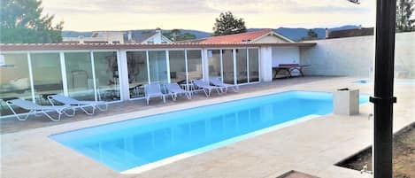 Piscina principal y al fondo la pequeña, detrás barbacoa y sala de ocio-gimnasio