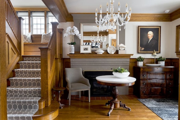 Stately Grand Entrance Hall with gas fireplace receives guests in style.