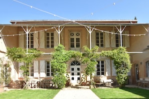 The walled courtyard, with a covered terrace and a table for 16 people